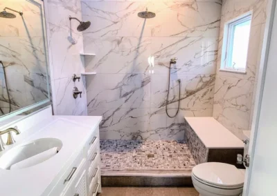 Bathroom completely renovated in porcelain shower walls and mosaic shower floor and large tile in main floor with a bench inside shower and glass door